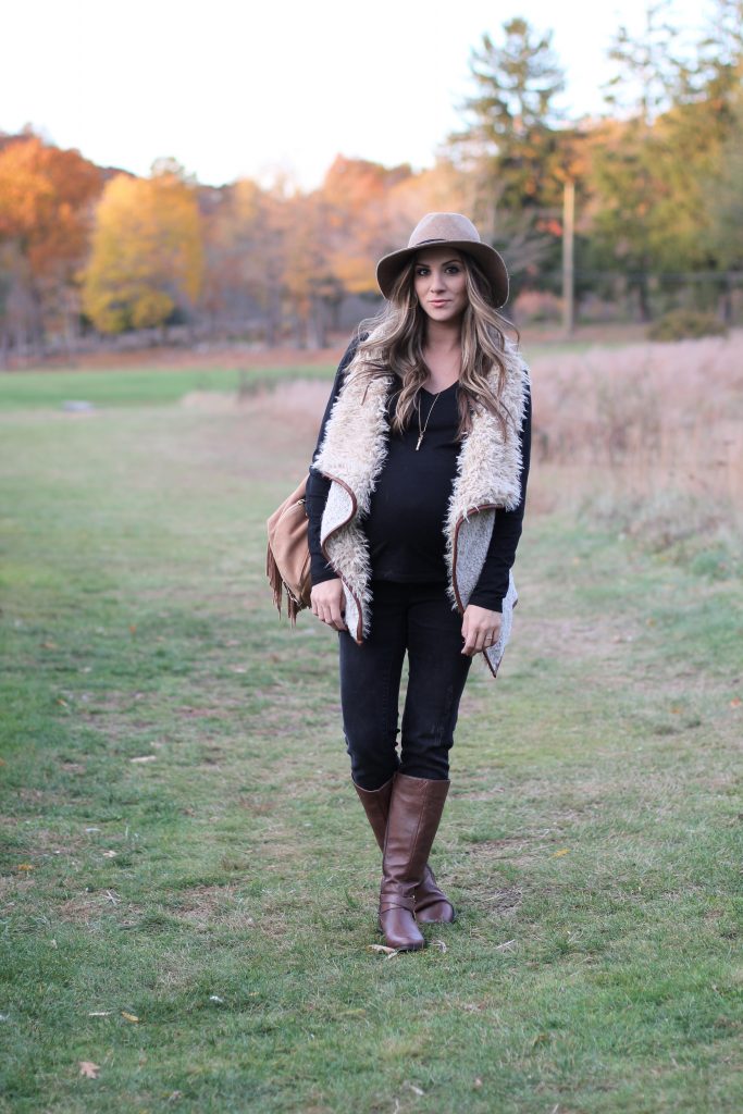 Fall maternity fashion in this fur and leather vest with a wool hat and riding boots.