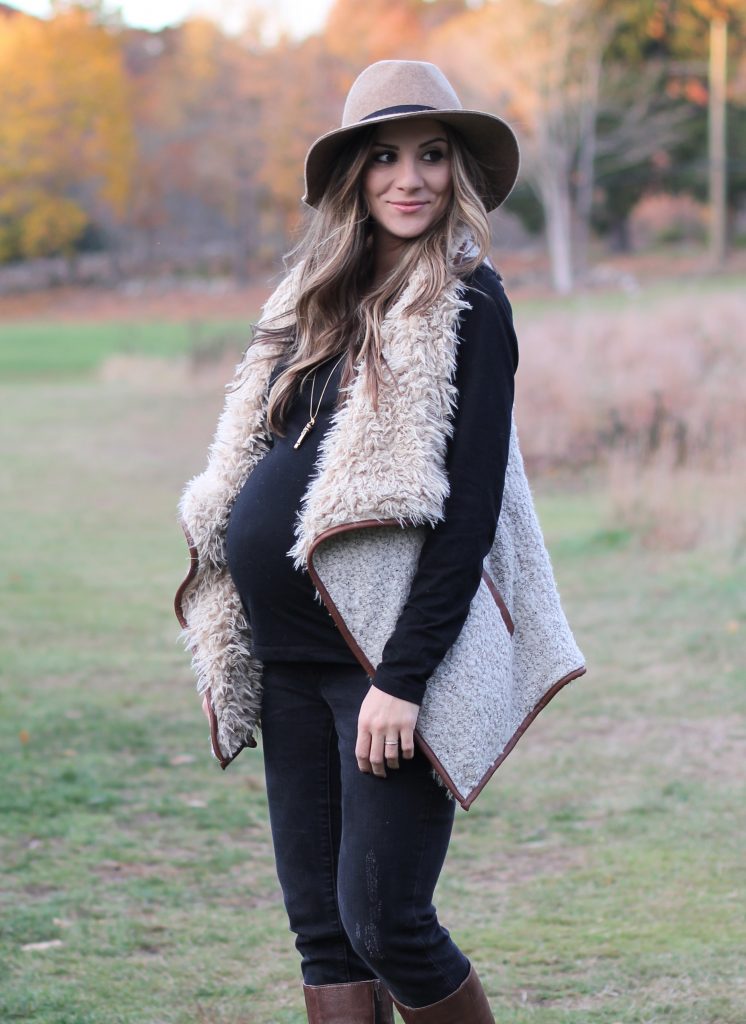 Fall maternity fashion in this fur and leather vest with a wool hat and riding boots.