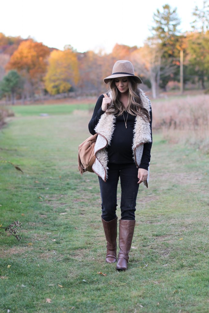 Fall maternity fashion in this fur and leather vest with a wool hat and riding boots.