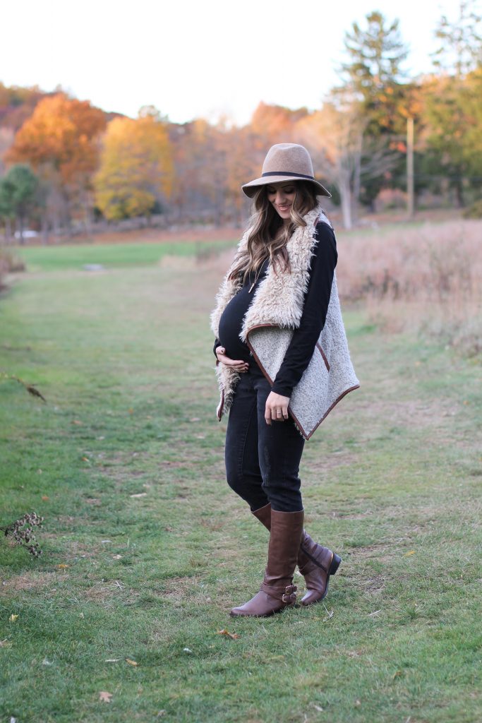 Fall maternity fashion in this fur and leather vest with a wool hat and riding boots.