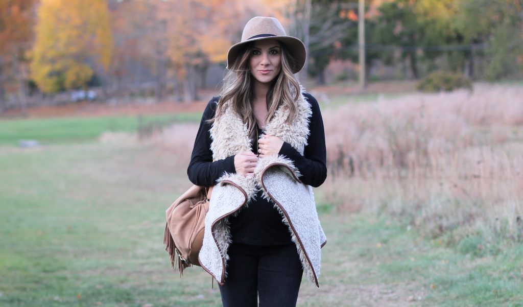 Fall maternity fashion in this fur and leather vest with a wool hat and riding boots.