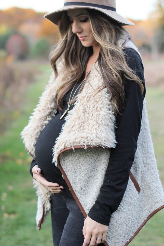 Fall maternity fashion in this fur and leather vest with a wool hat and riding boots.