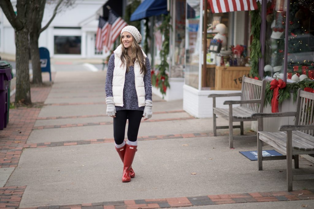 Cozy casual mom outfit with red Hunter boots, leggings, an oversized sweater, and puffy vest.