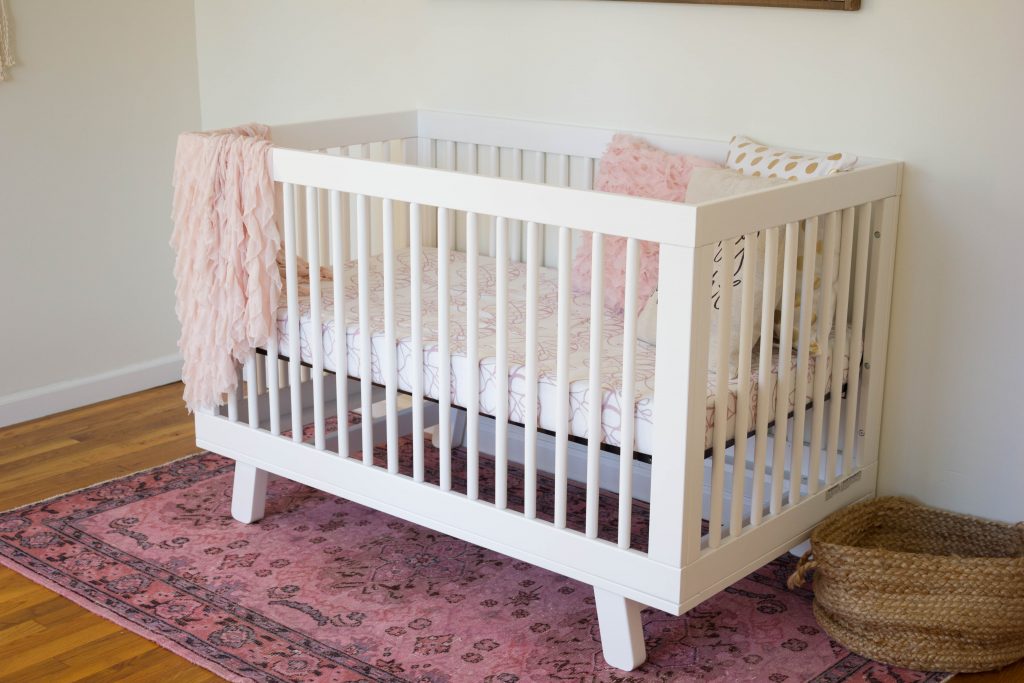 A gorgeous boho glam baby girl nursery, featuring the Babyletto Hudson Crib and Delta Children Avery Glider