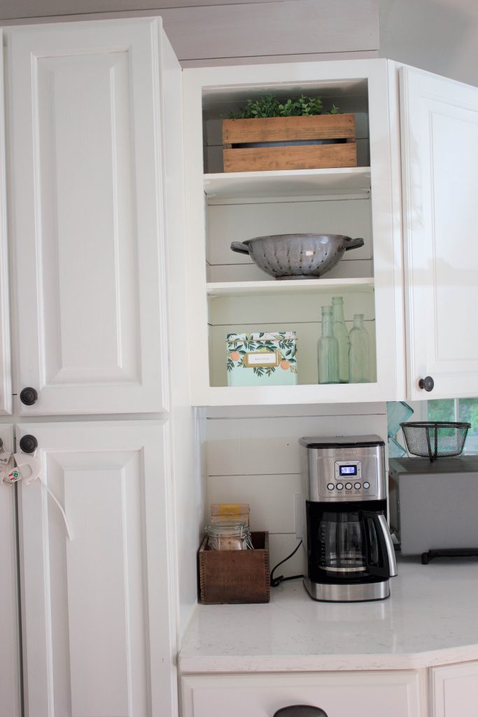 Farmhouse kitchen with shiplap walls, quartz countertops, and vintage accents