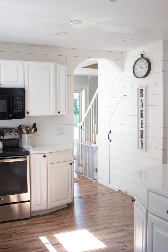 Farmhouse kitchen with shiplap walls, quartz countertops, and vintage accents