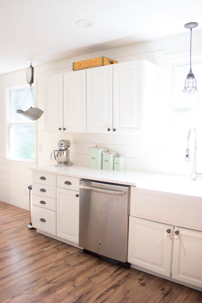 Farmhouse kitchen with shiplap walls, quartz countertops, and vintage accents