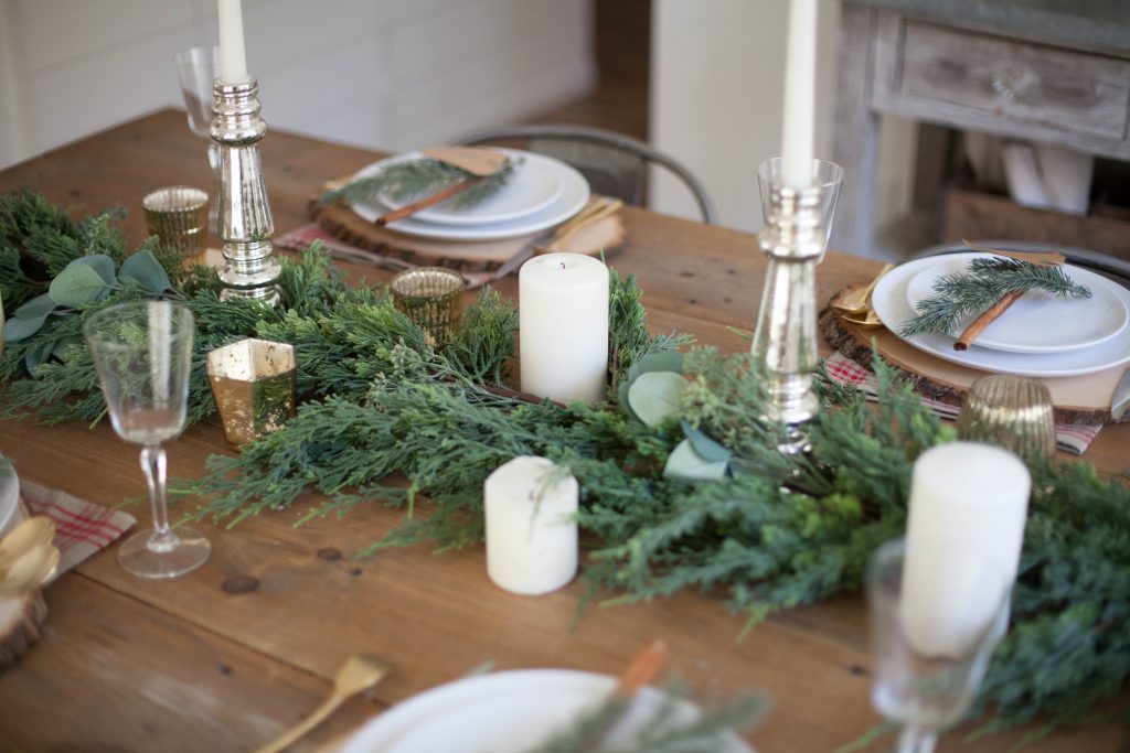 A beautiful farmhouse Christmas tablescape with rustic elements, mixed metals, and natural greenery. Perfect for a hosting a holiday dinner!