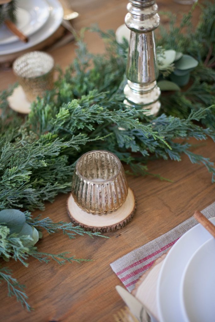 A beautiful farmhouse Christmas tablescape with rustic elements, mixed metals, and natural greenery. Perfect for a hosting a holiday dinner!