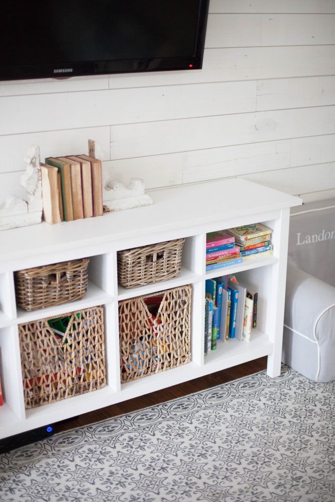 A cottage style playroom that functions as a family room as well, while keeping it kid-friendly with a variety of storage options for easy pick up.