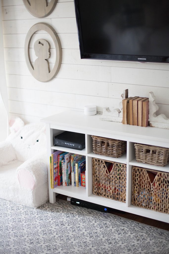 A cottage style playroom that functions as a family room as well, while keeping it kid-friendly with a variety of storage options for easy pick up.