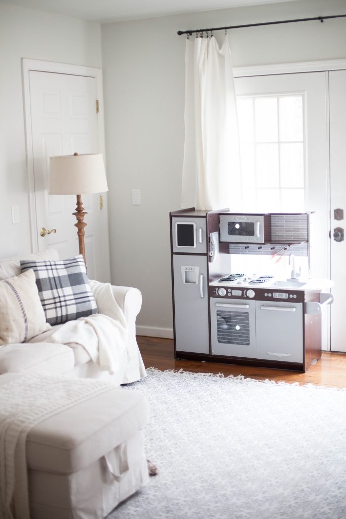 A cottage style playroom that functions as a family room as well, while keeping it kid-friendly with a variety of storage options for easy pick up.