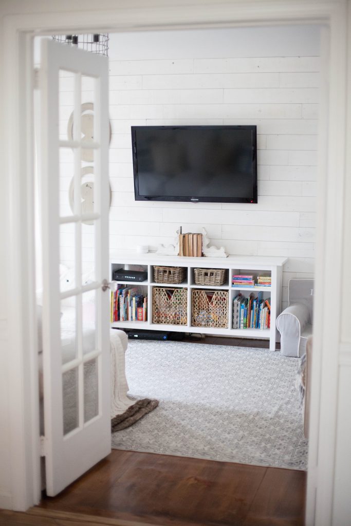 A cottage style playroom that functions as a family room as well, while keeping it kid-friendly with a variety of storage options for easy pick up.