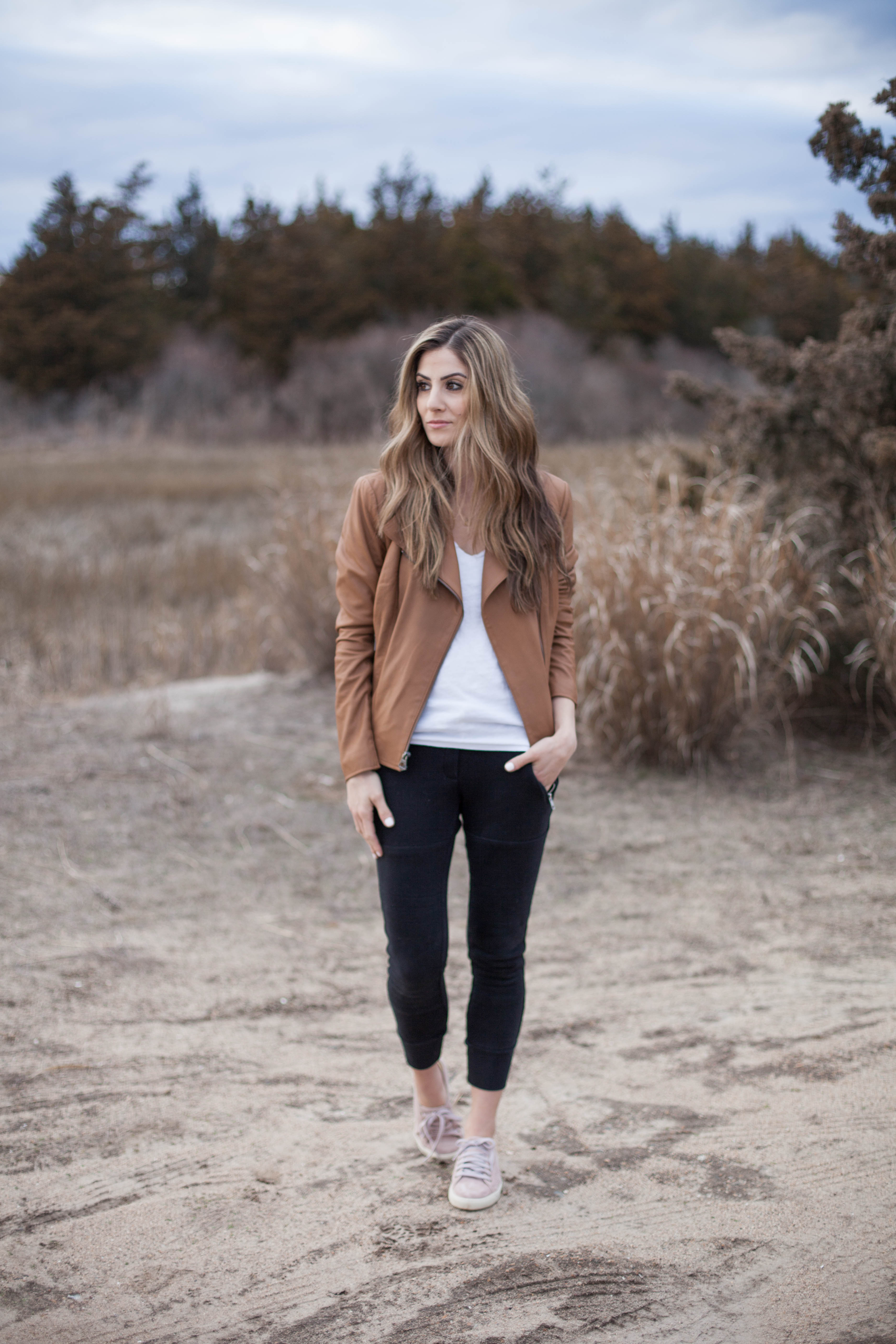 A simple way to style spring sneakers, featuring jogger pants and a classic leather jacket. This casual look is perfect for chilly spring days!