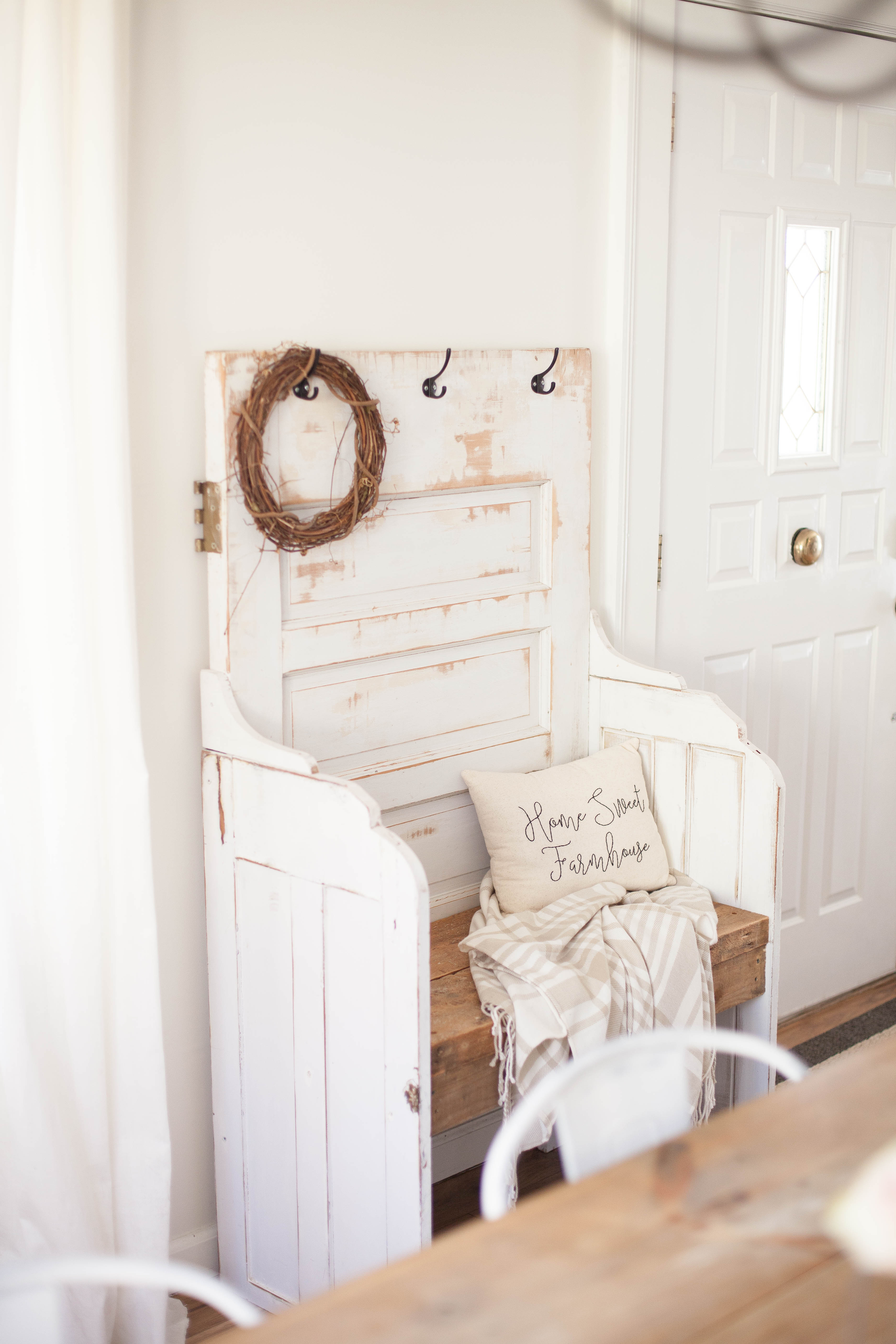 This spring cottage dining room features a handmade bench that was created from an antique door!