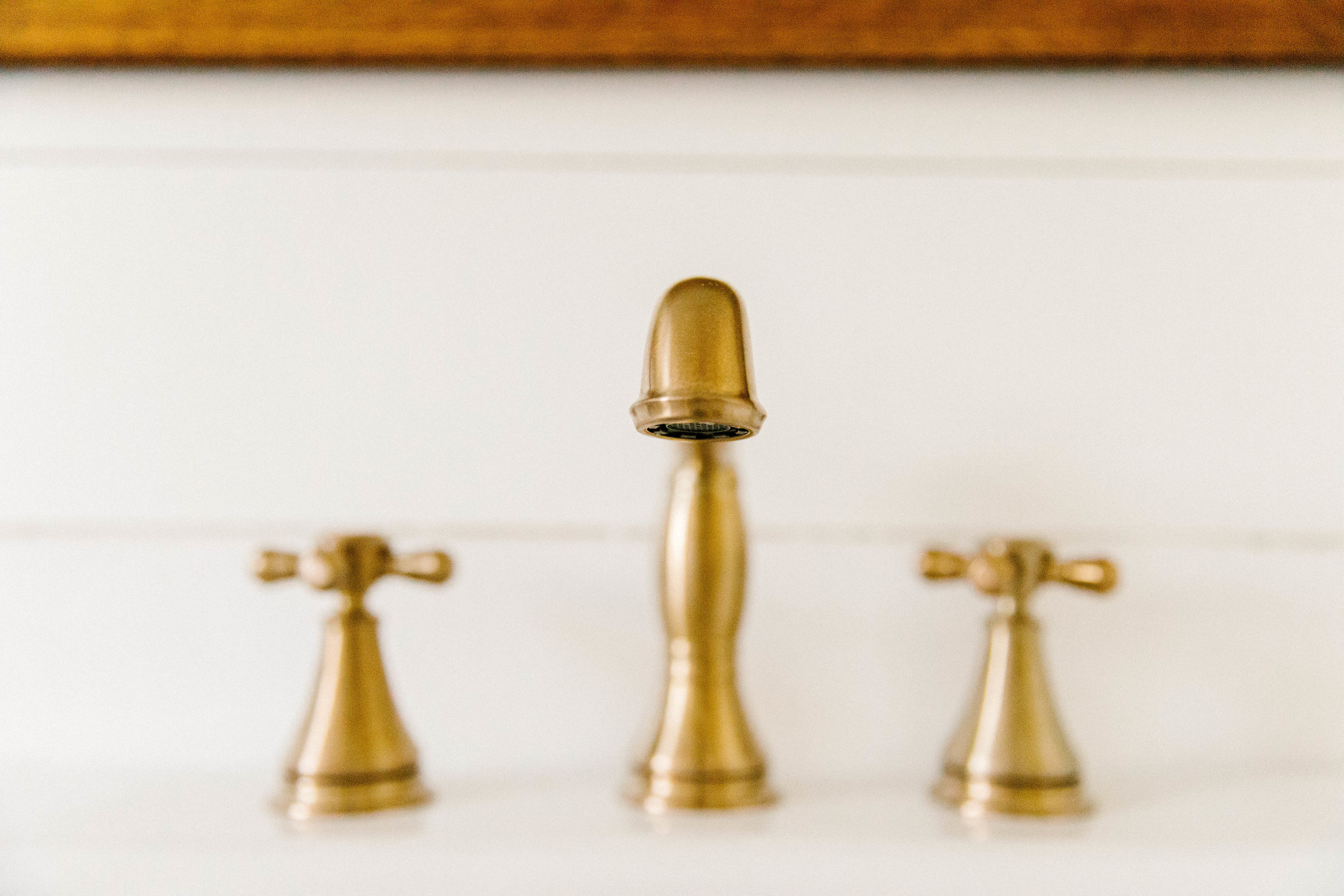 Delta Faucet's Cassidy Wide Spread bathroom faucet is perfect for a vintage dresser vanity with a farmhouse sink.