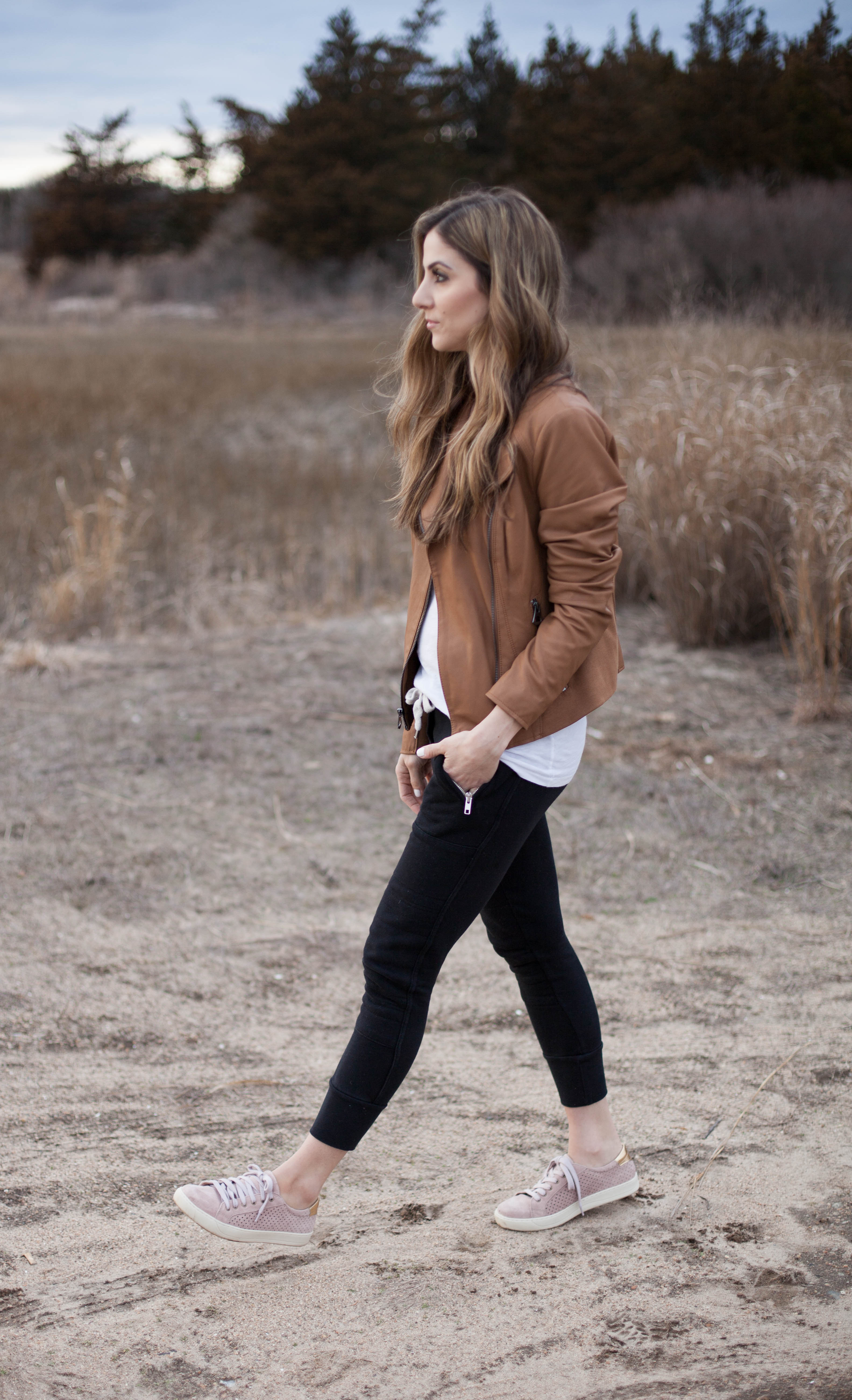 A simple way to style spring sneakers, featuring jogger pants and a classic leather jacket. This casual look is perfect for chilly spring days!