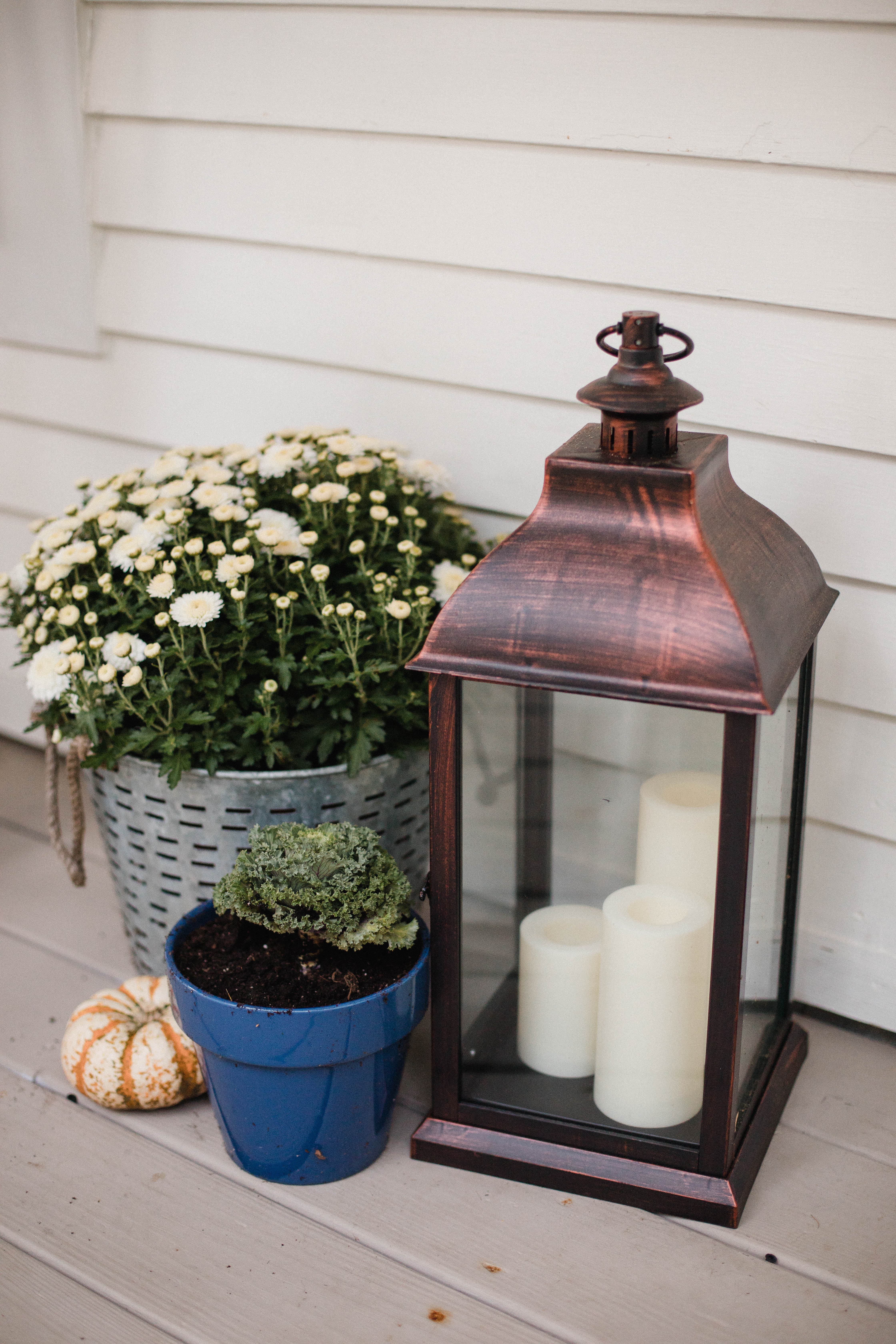 Life and style blogger Lauren McBride shares her Fall Front Porch featuring a mix of natural and vintage elements as well as outdoor lanterns with flameless candles. 