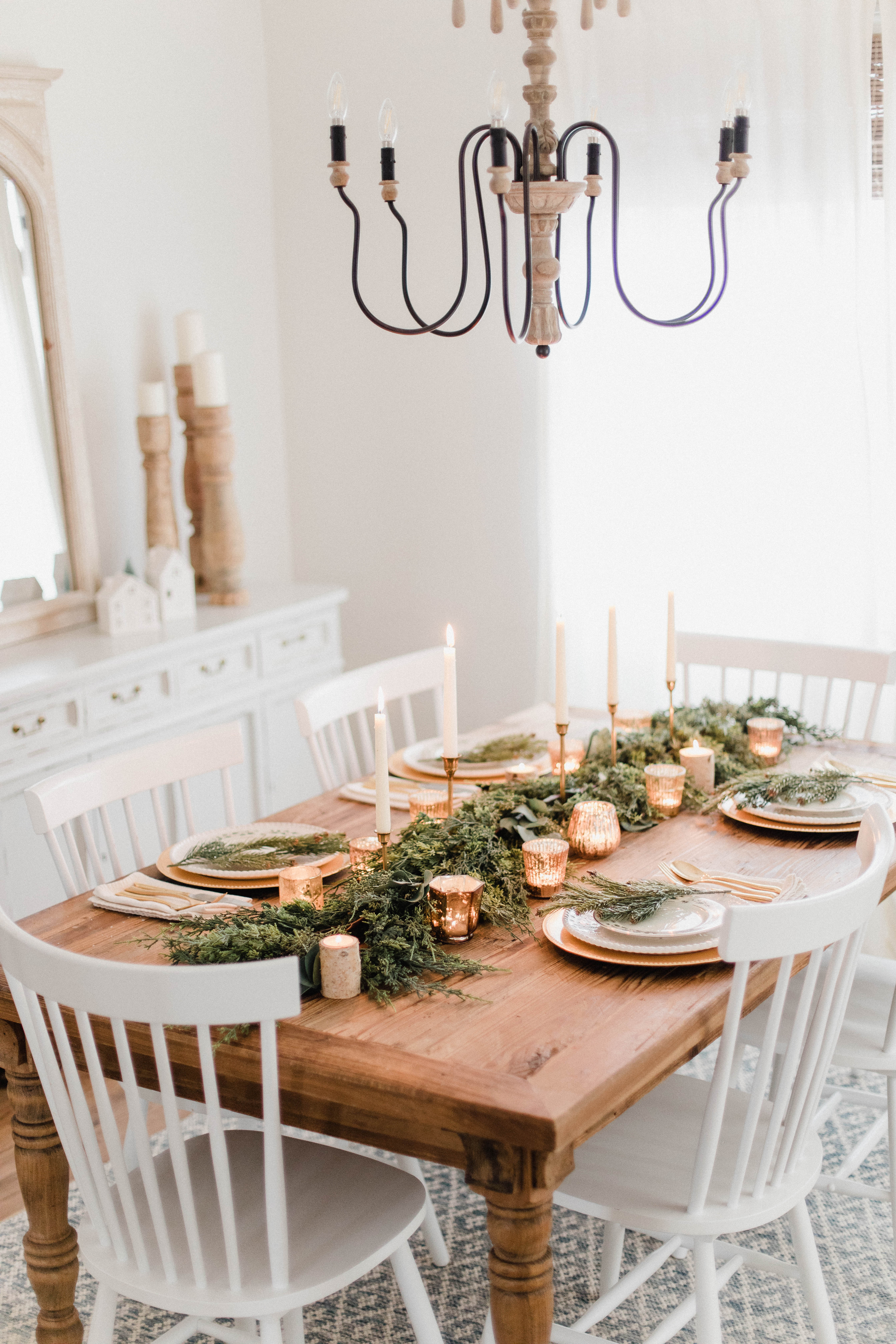 Connecticut life and style blogger Lauren McBride shares a white and gold Christmas tablescape featuring a mix of faux greenery, metallics, and antique touches. 