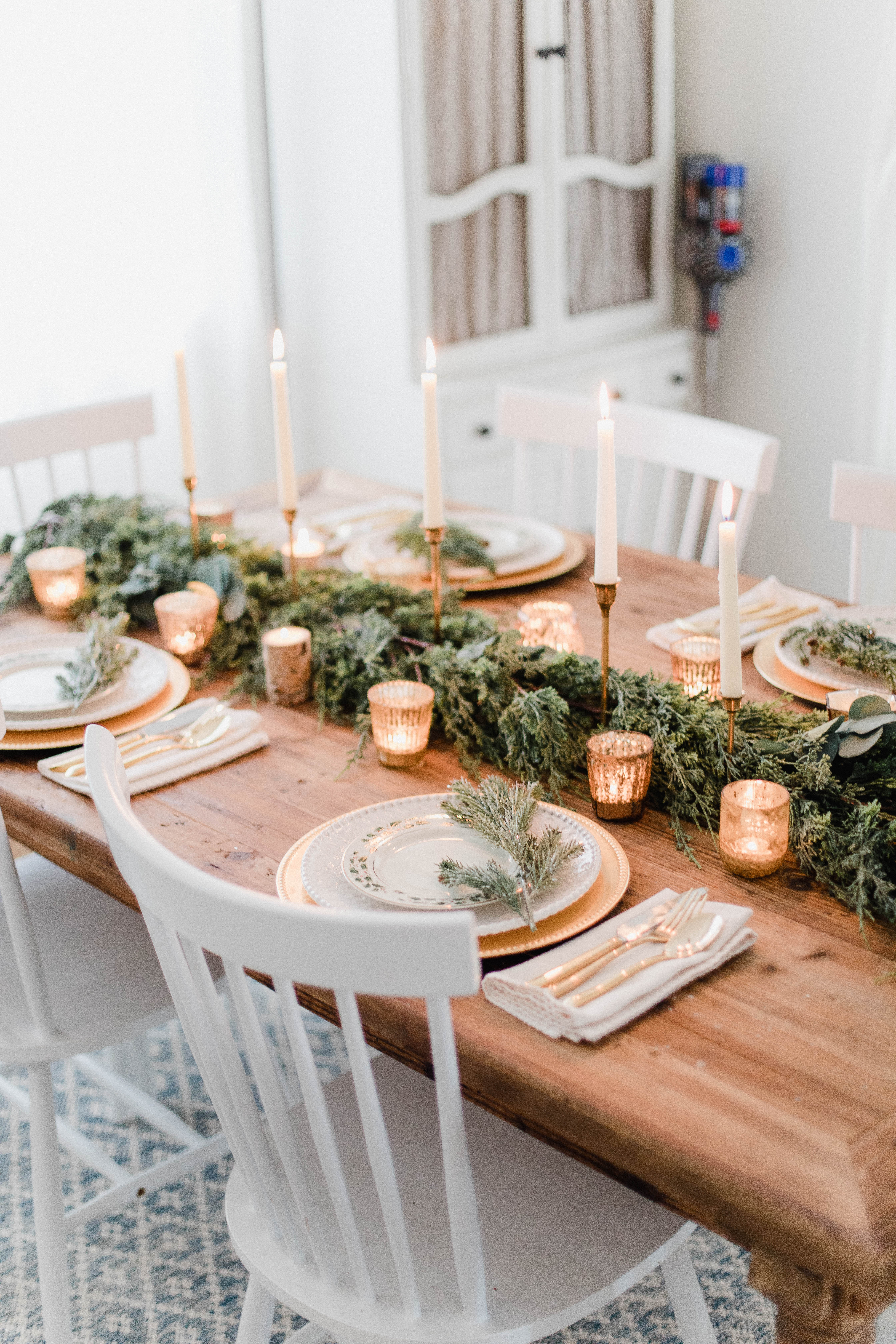 Connecticut life and style blogger Lauren McBride shares a white and gold Christmas tablescape featuring a mix of faux greenery, metallics, and antique touches. 