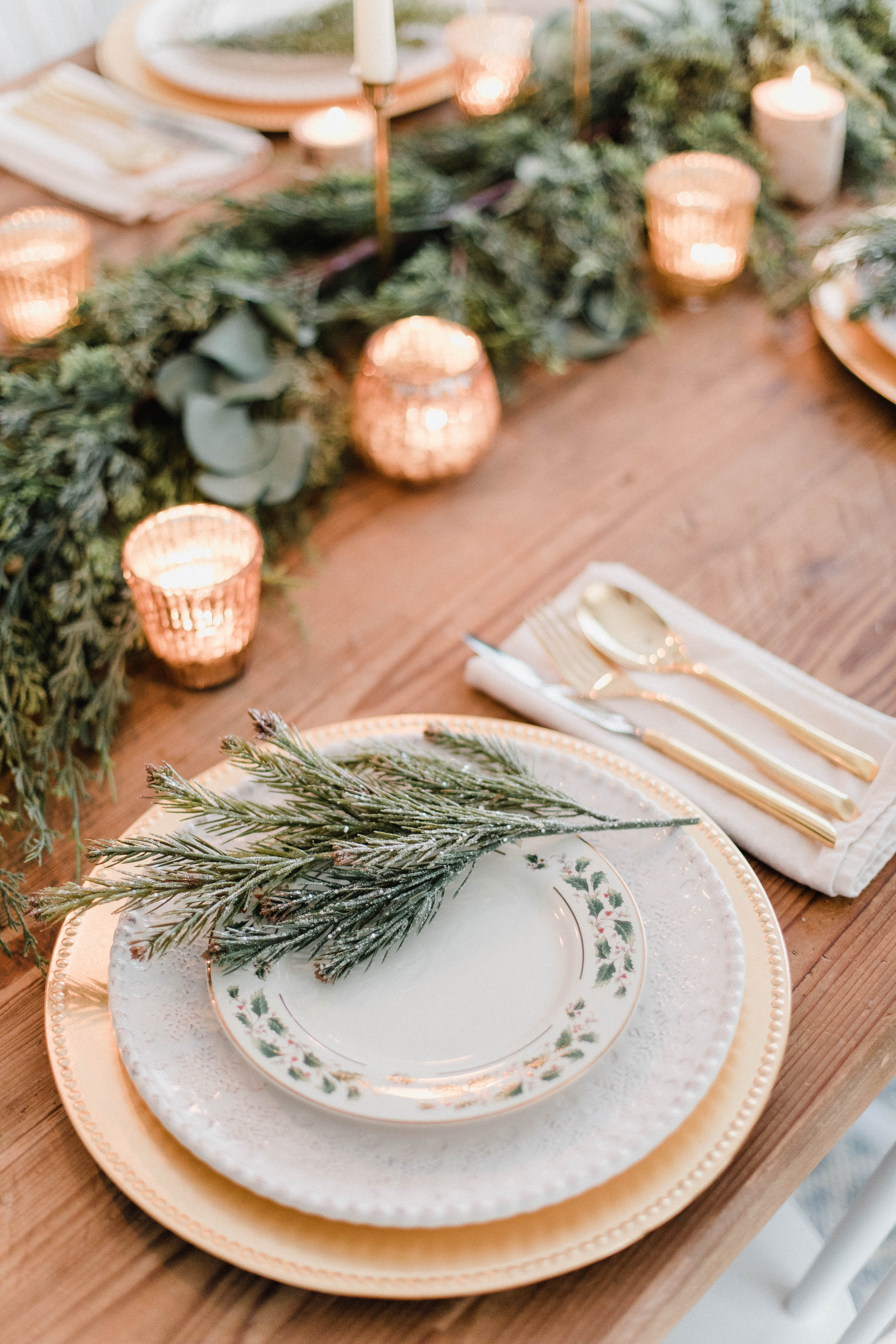 Connecticut life and style blogger Lauren McBride shares a white and gold Christmas tablescape featuring a mix of faux greenery, metallics, and antique touches. 