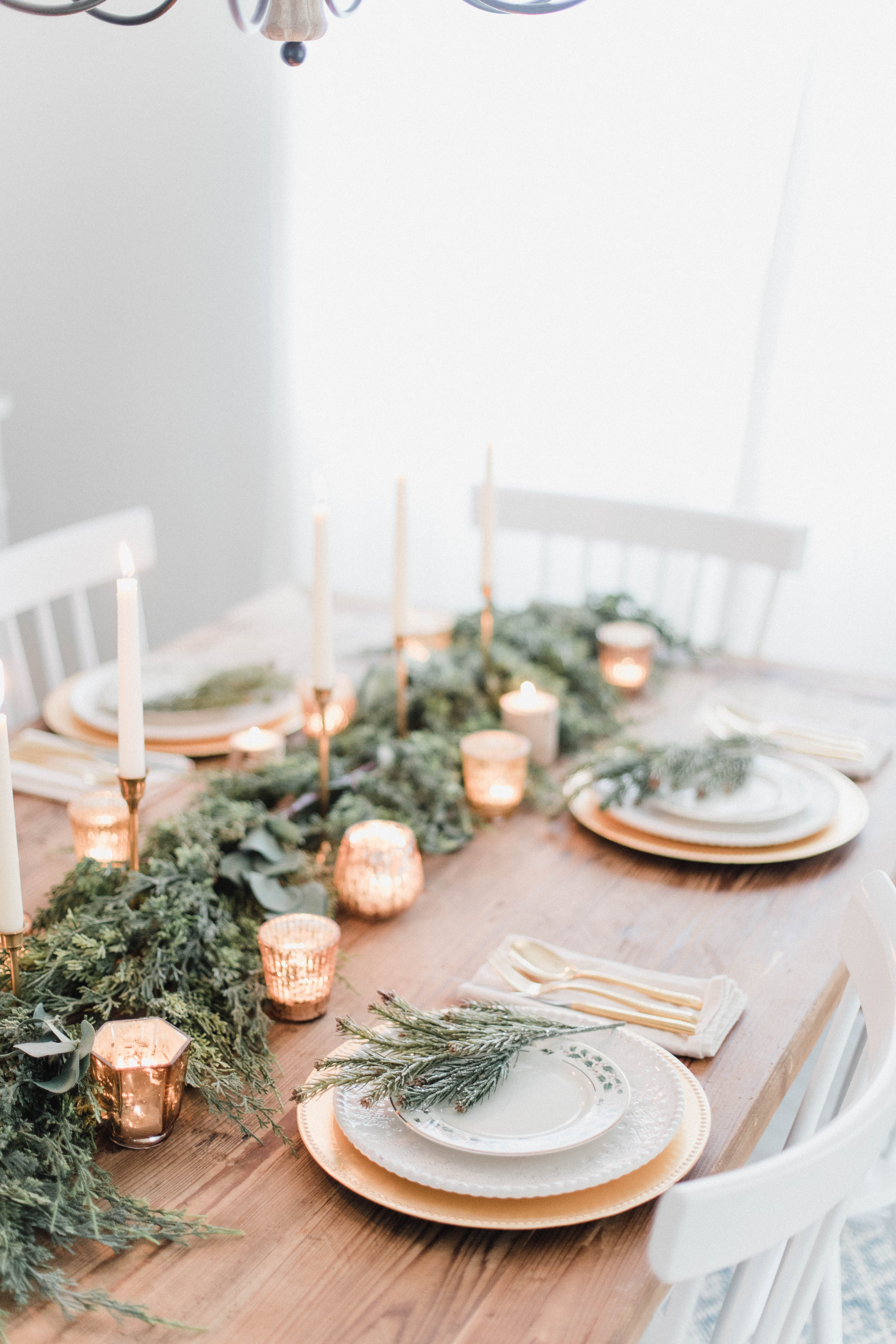 Connecticut life and style blogger Lauren McBride shares a white and gold Christmas tablescape featuring a mix of faux greenery, metallics, and antique touches. 