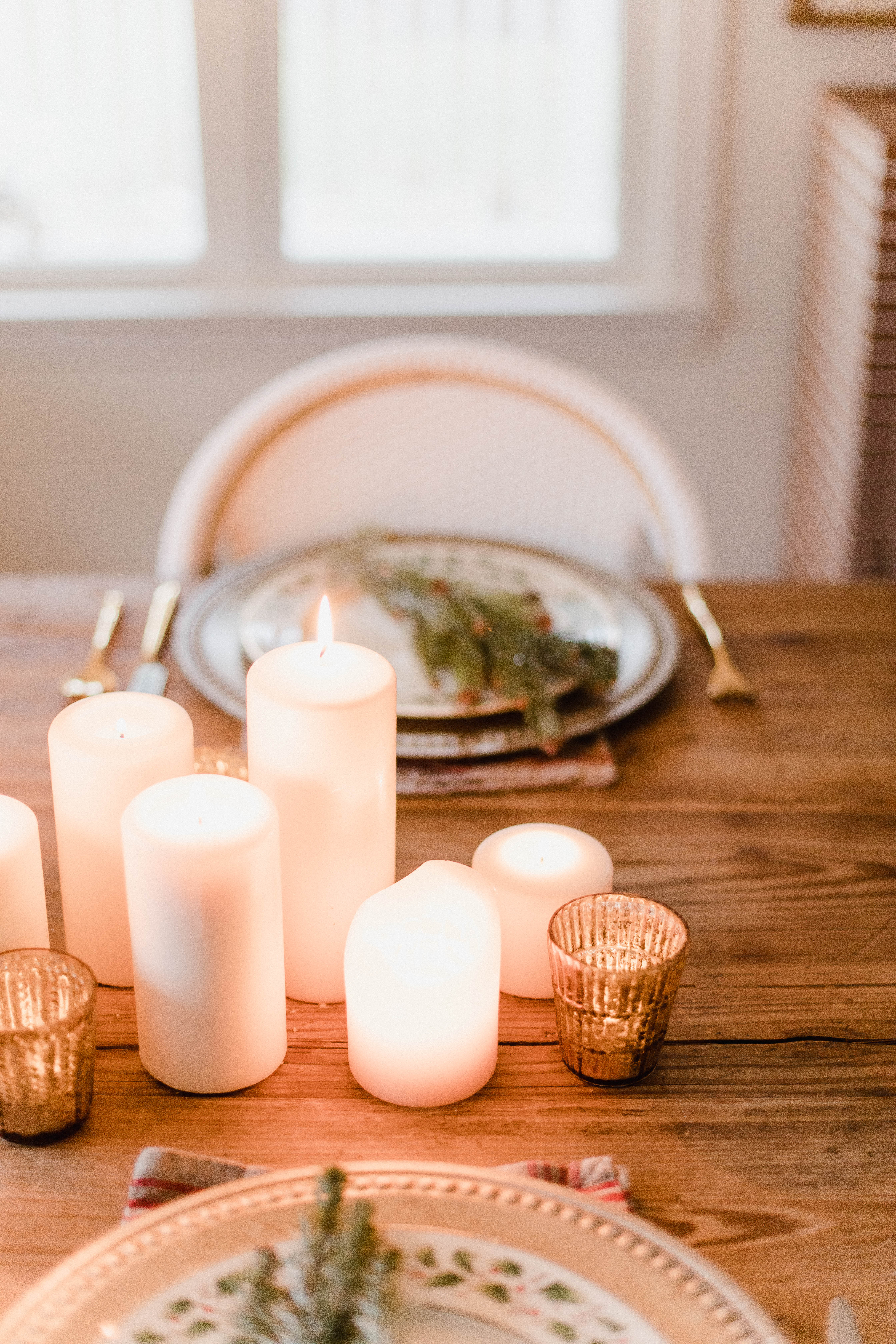 Connecticut life and style blogger Lauren McBride shares a Romantic Holiday Tablescape featuring romantic, cozy vibes with candles and a festive place setting.