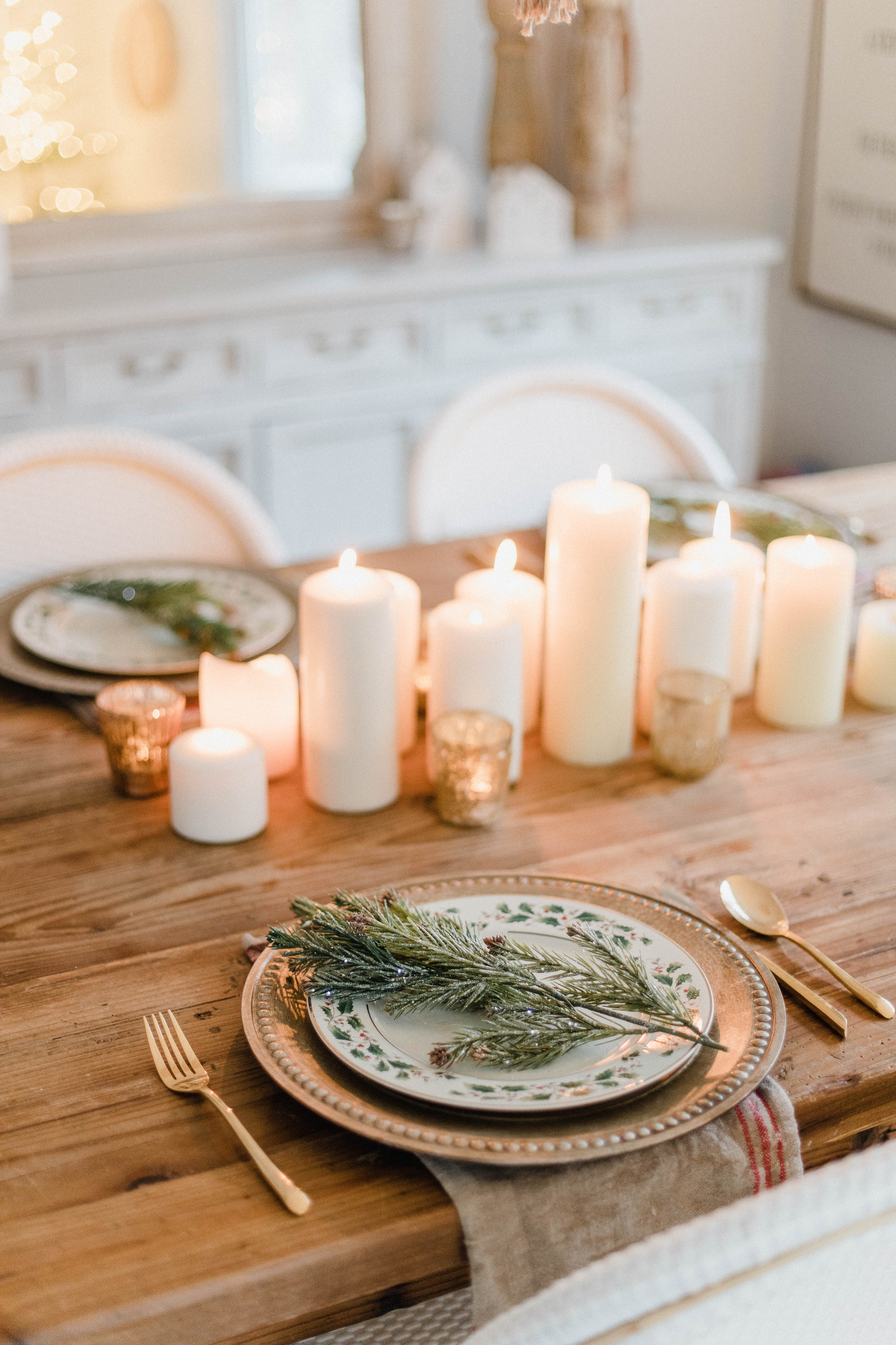 Connecticut life and style blogger Lauren McBride shares a Romantic Holiday Tablescape featuring romantic, cozy vibes with candles and a festive place setting.